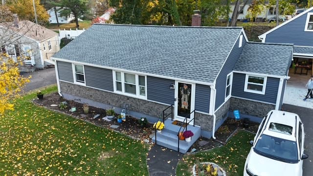 Pattison Construction new roof on a Connecticut ranch home with stone veneer accents — aerial autumn view